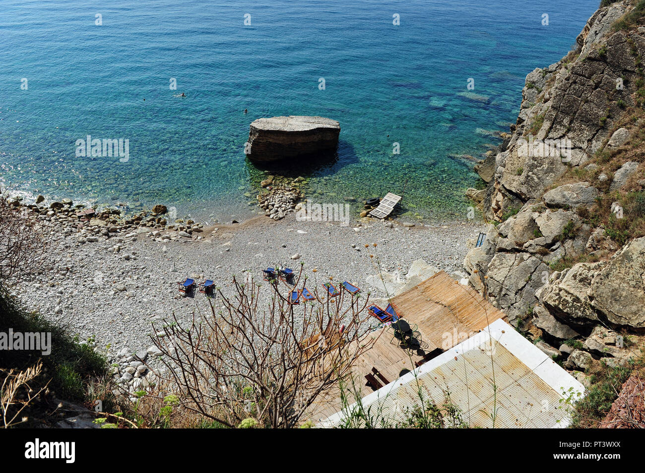 Piccola spiaggia appartata in Montenegro. Clear all oceano due nuotatori in distanza. Foto orizzontale con copia spazio. Foto Stock