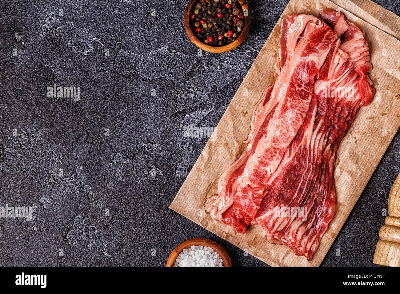 Porzione di materie Bacon strisce sullo sfondo scuro, vista dall'alto. Foto Stock