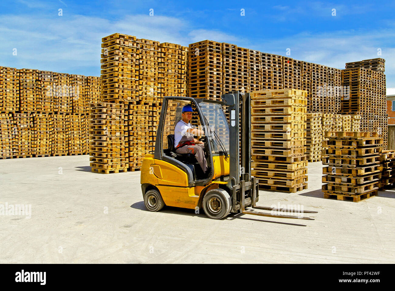 Operatore carrello elevatore a forche in magazzino per pallet sull'aperto Foto Stock