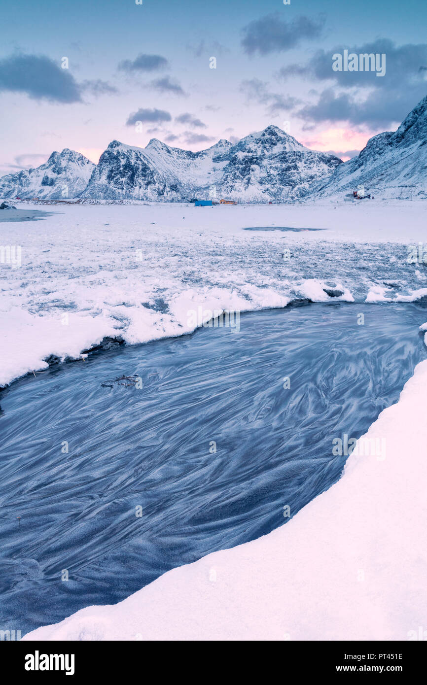 Mare ghiacciato, circondato da neve, Skagsanden, comune di Flakstad, Isole Lofoten in Norvegia Foto Stock