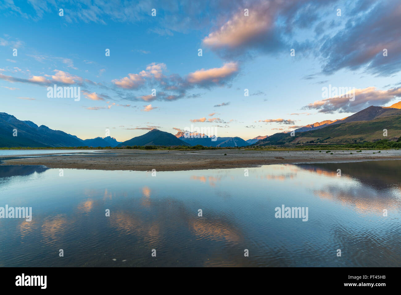 Nuvole nel cielo sopra sul lago Wakatipu e sulle montagne al tramonto, Glenorchy, Queenstown distretto dei laghi, regione di Otago, South Island, in Nuova Zelanda, Foto Stock
