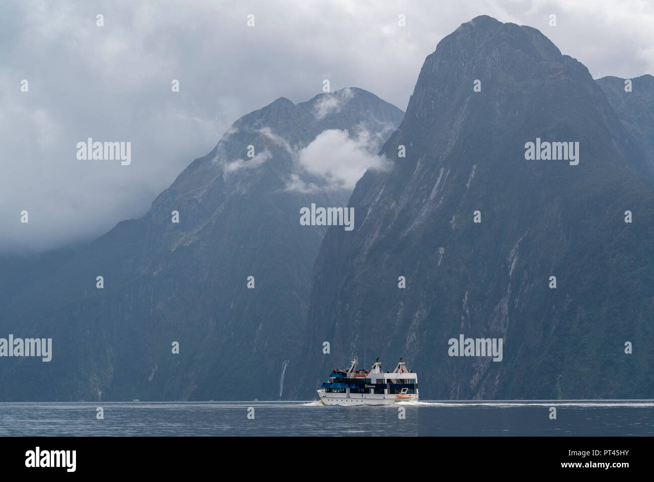 Barca e montagne in Milford Sound in estate, Fiordland NP, Southland district, regione del Southland, South Island, in Nuova Zelanda, Foto Stock