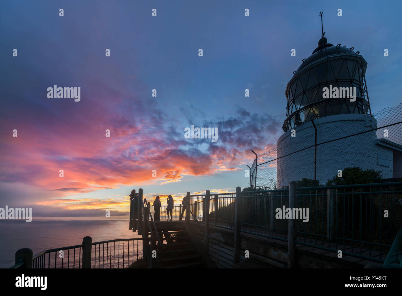Tramonto al Nugget Point lighthouse, Ahuriri piana, Clutha distretto, regione di Otago, South Island, in Nuova Zelanda, Foto Stock