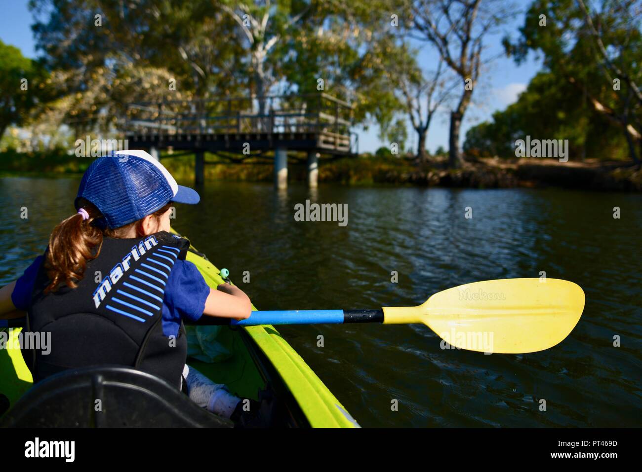 Bambini sguazzare in una canoa in bel tempo, del fiume Ross QLD, Australia Foto Stock