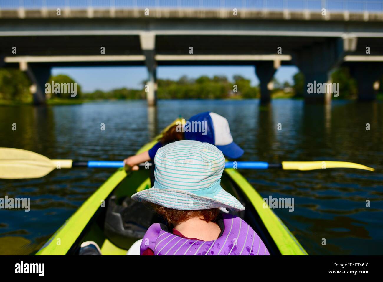 Bambini sguazzare in una canoa in bel tempo, del fiume Ross QLD, Australia Foto Stock