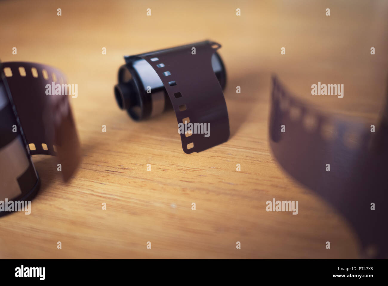I rotoli di pellicola da 35 mm per telecamere sul tavolo di legno Foto Stock