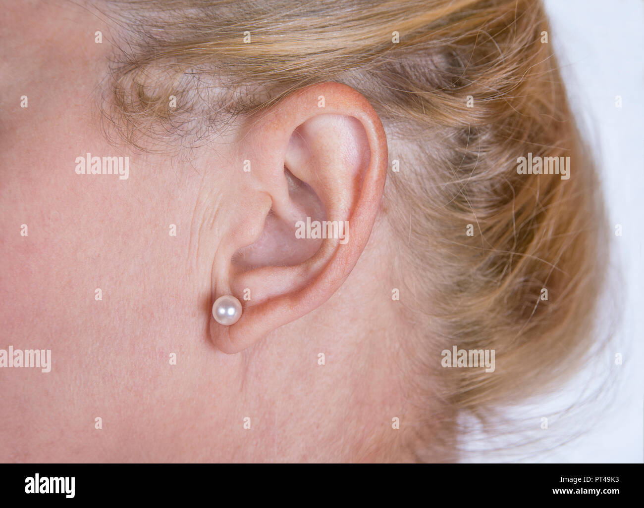 Donna matura orecchio con orecchino e capelli biondi Foto Stock