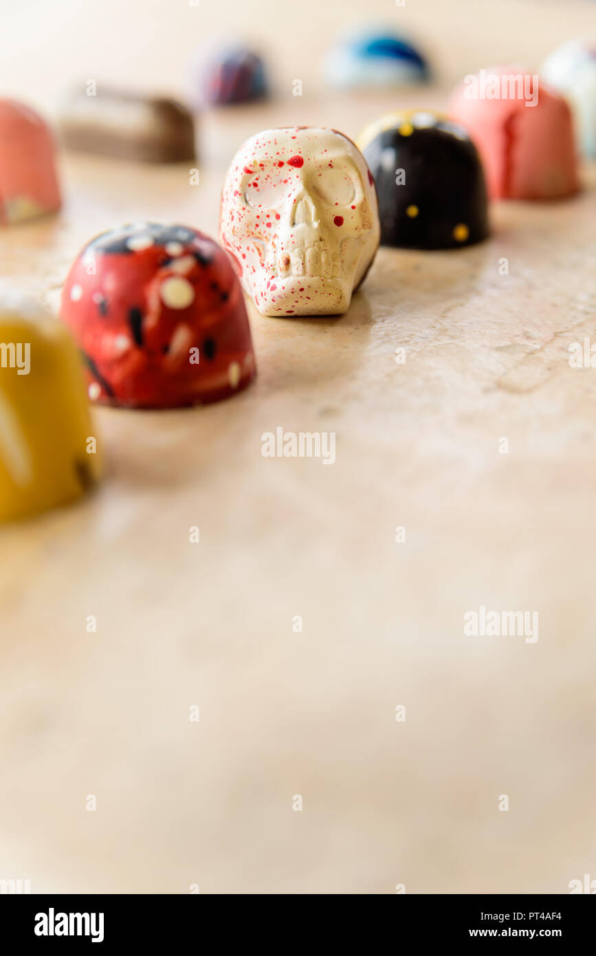 Cranio di cioccolato tra colorate in casa bomboni. Foto Stock