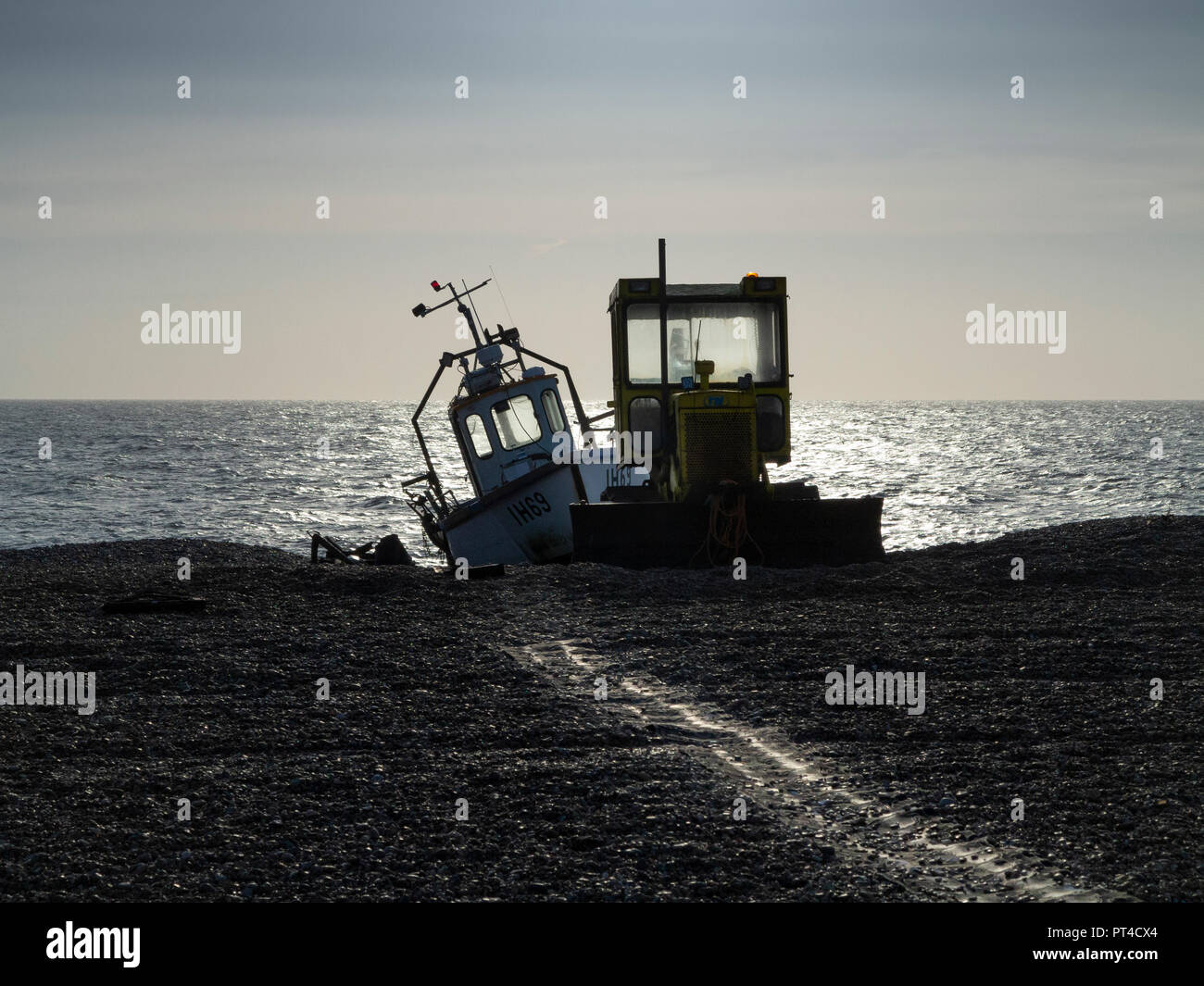 Bulldozer utilizzato come lanciatore in barca e la spiaggia di ciottoli raschiatore con barca da pesca dietro contro il mare orizzonte linea spiaggia di Aldeburgh Suffolk in Inghilterra Foto Stock