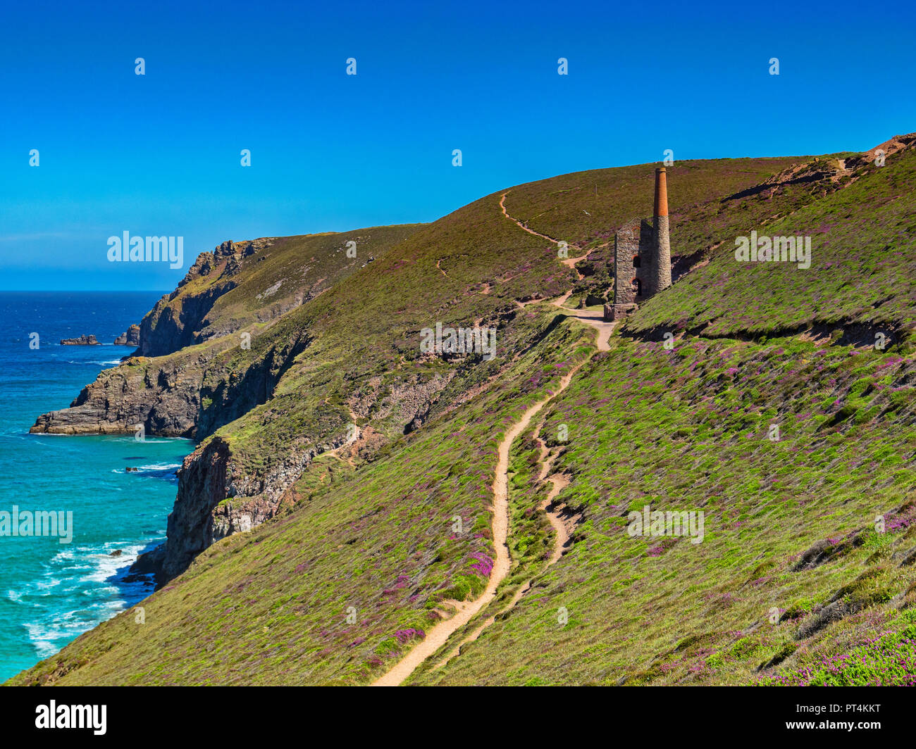 La South West Coast Path, snodandosi sopra le scogliere della Cornovaglia e passando dalla Towenroath Casa del motore, parte dell'Wheal Coates miniera, Cornwall Foto Stock