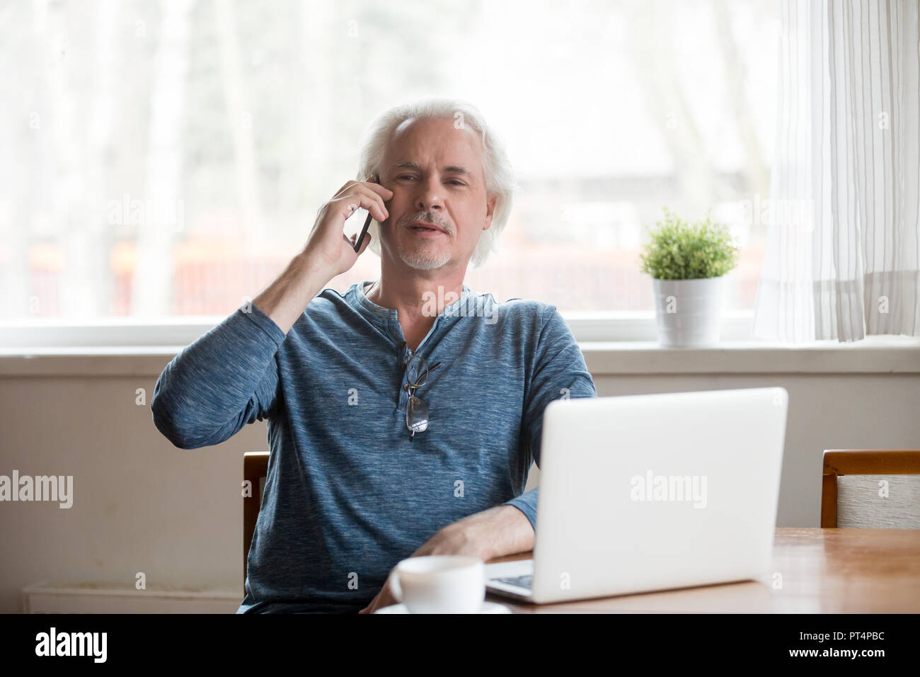 Senior uomo maturo parlando al telefono di effettuazione della chiamata a casa Foto Stock