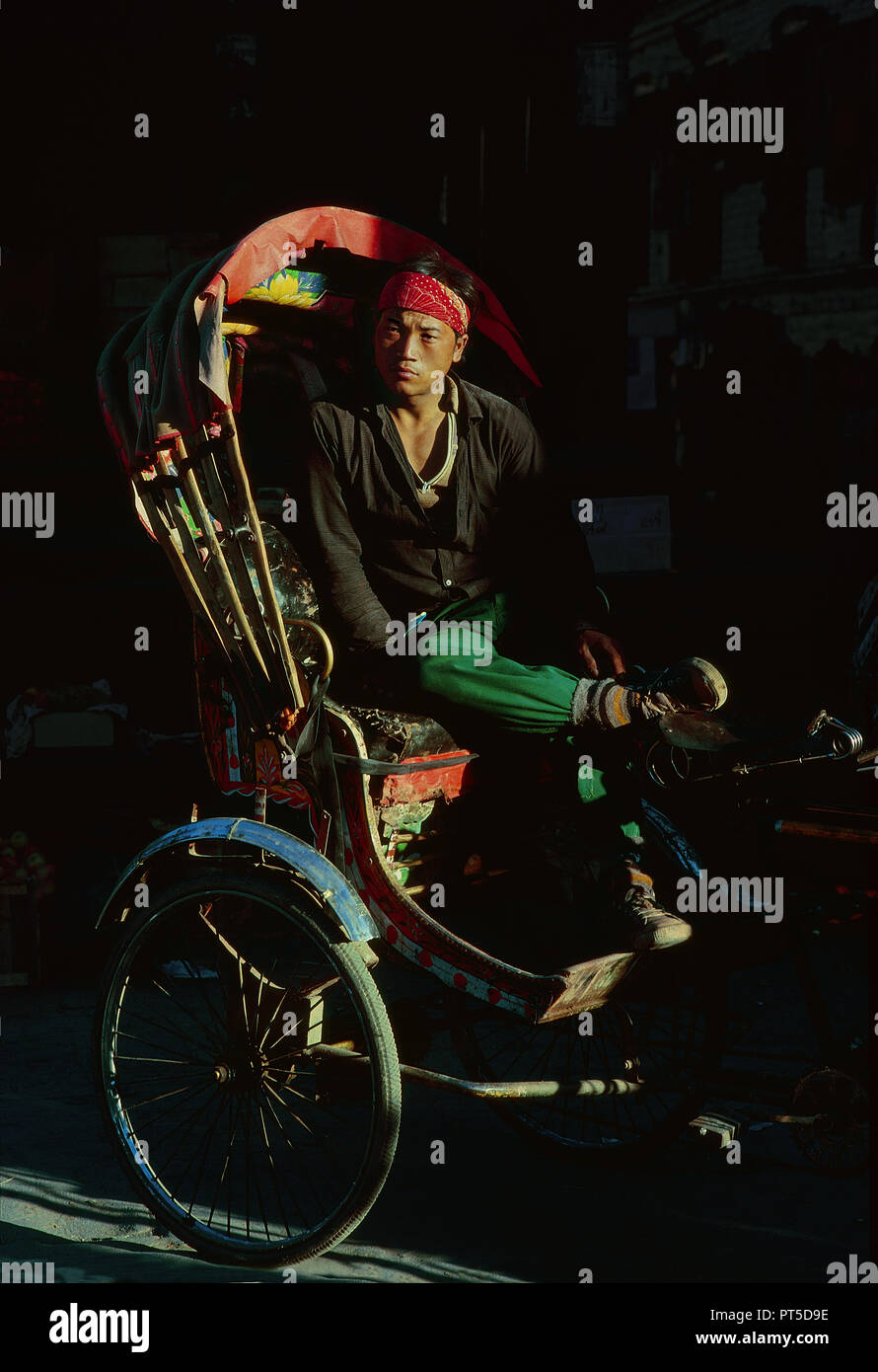 In rickshaw man è in appoggio alla fine della giornata. Fotografia analogica Foto Stock
