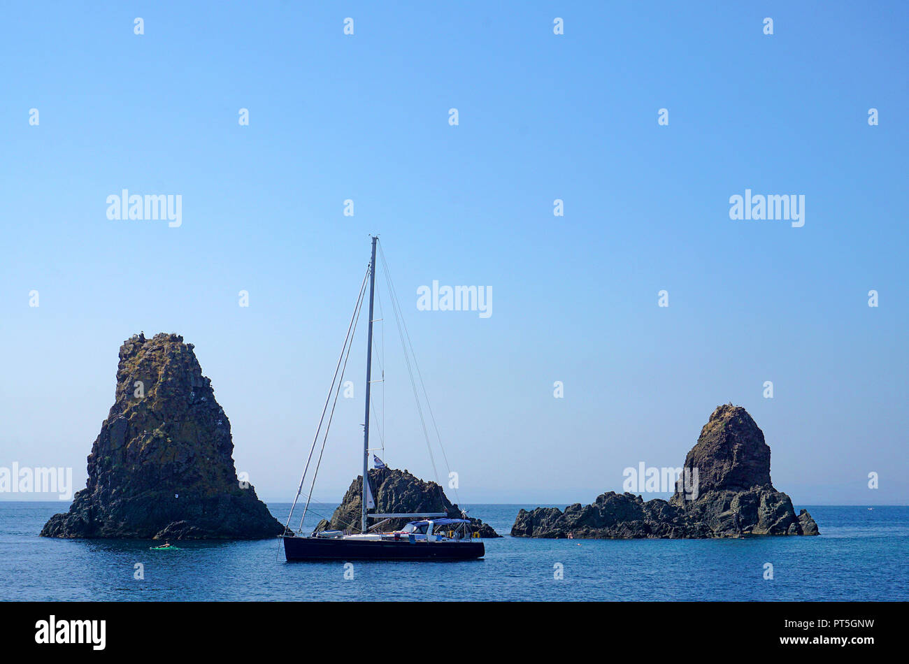 Barca a vela presso le isole dei ciclopi al villaggio di pescatori di Aci Trezza, comune di Aci Castello, Catania, Sicilia, Italia Foto Stock