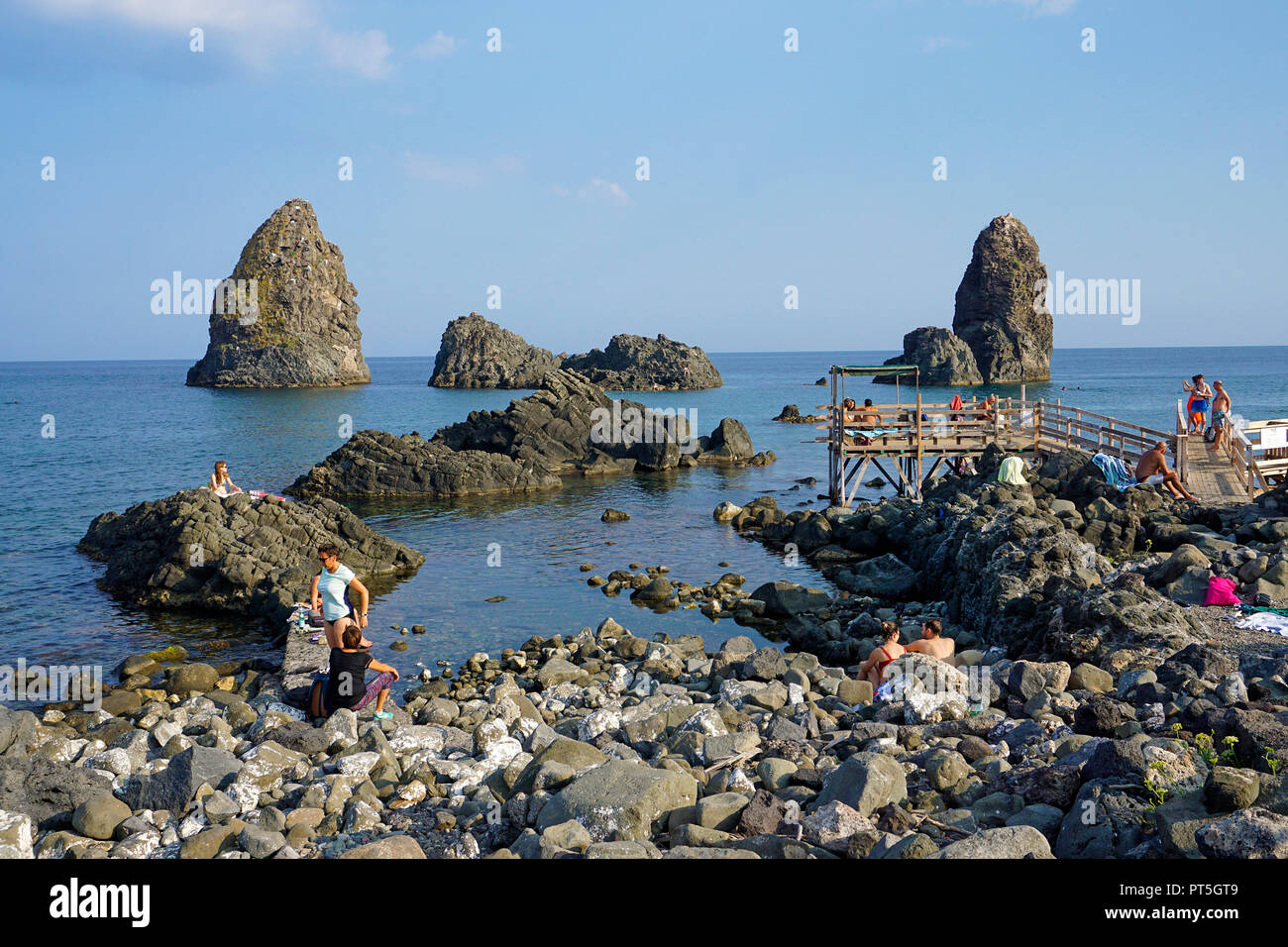 Le persone a un Lido, isole dei Ciclopi, villaggio di pescatori di Aci Trezza, comune di Aci Castello, Catania, Sicilia, Italia Foto Stock