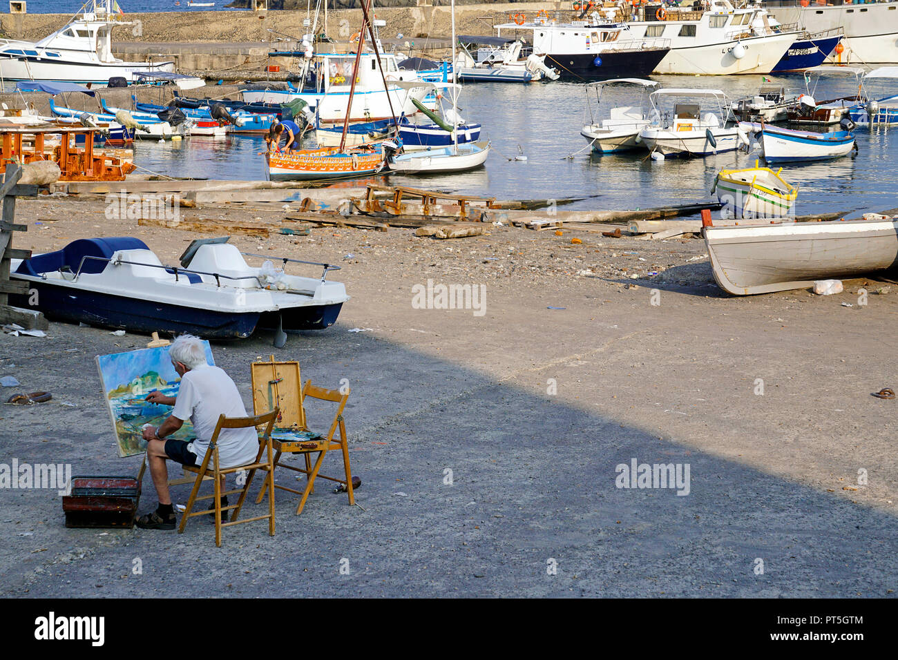 Pittore al porto del villaggio di pescatori di Aci Trezza, comune di Aci Castello, Catania, Sicilia, Italia Foto Stock