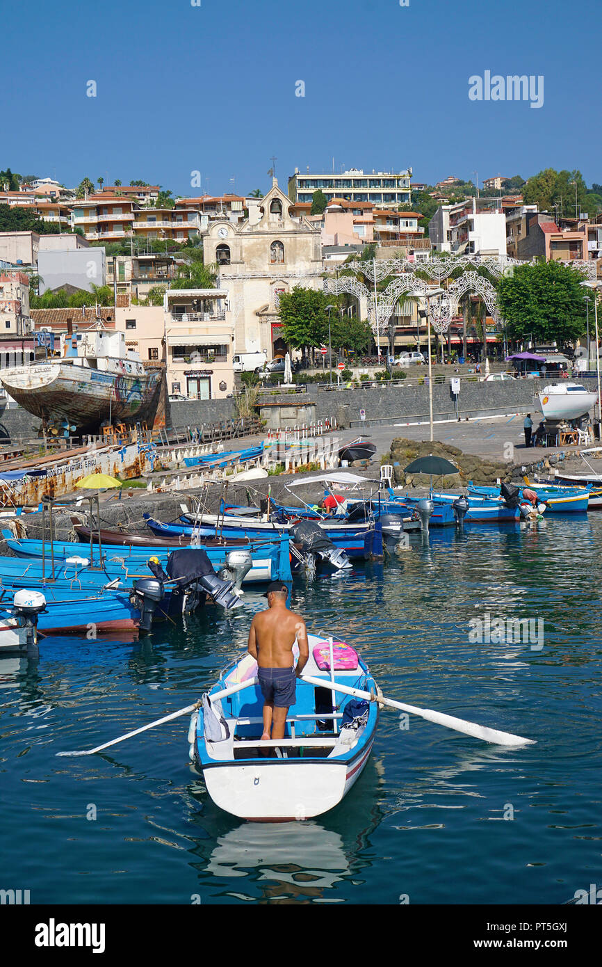 Pescatore con canotto a porto del villaggio di pescatori di Aci Trezza, comune di Aci Castello, Catania, Sicilia, Italia Foto Stock