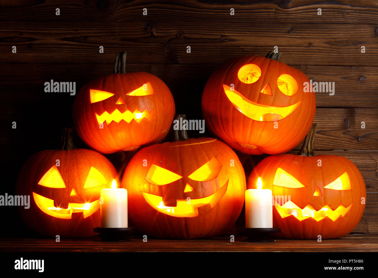 Gruppo di zucca di Halloween jack testa o lanterna e candele su scuro dello sfondo in legno Foto Stock