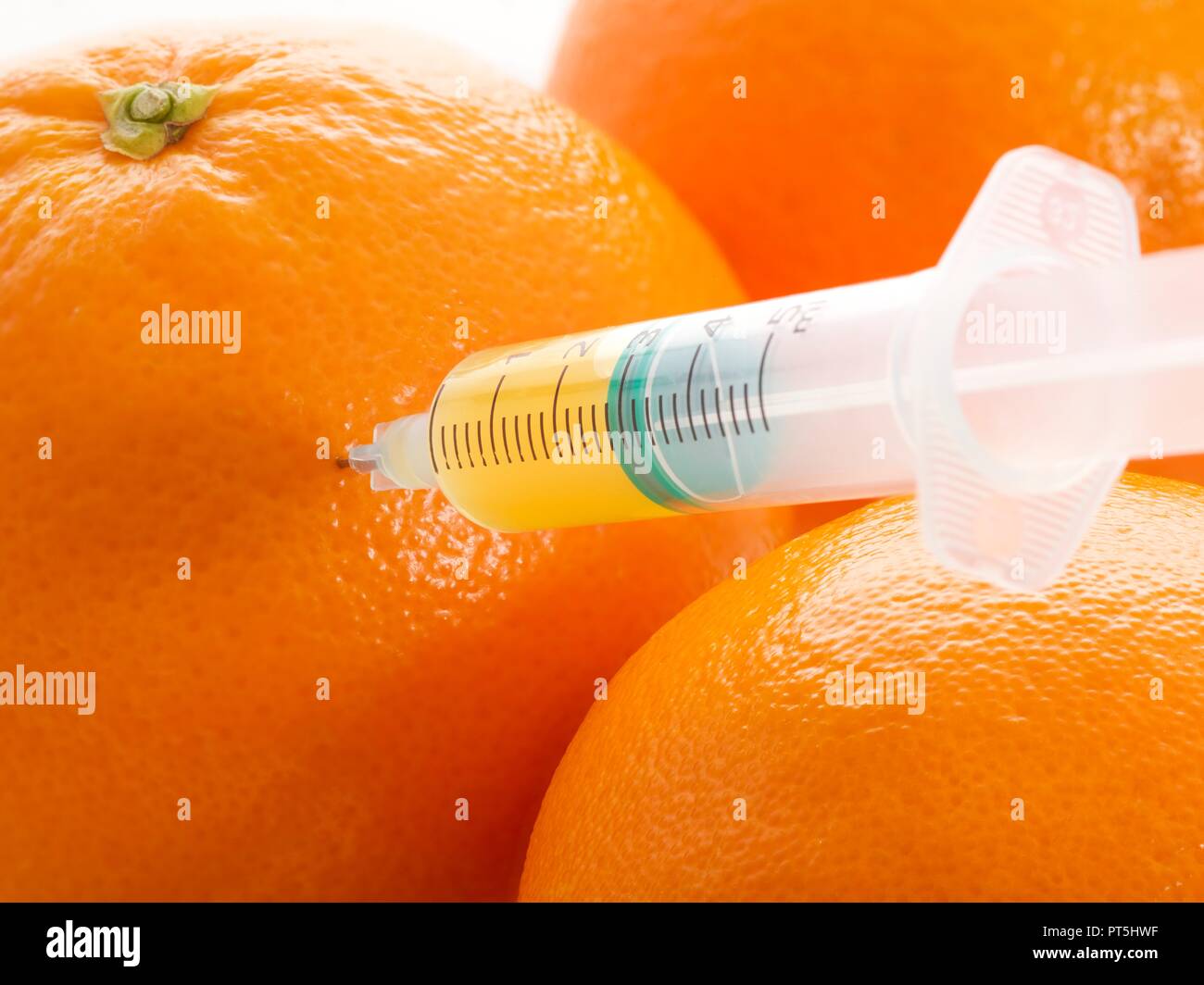 Le arance con la siringa. Foto Stock