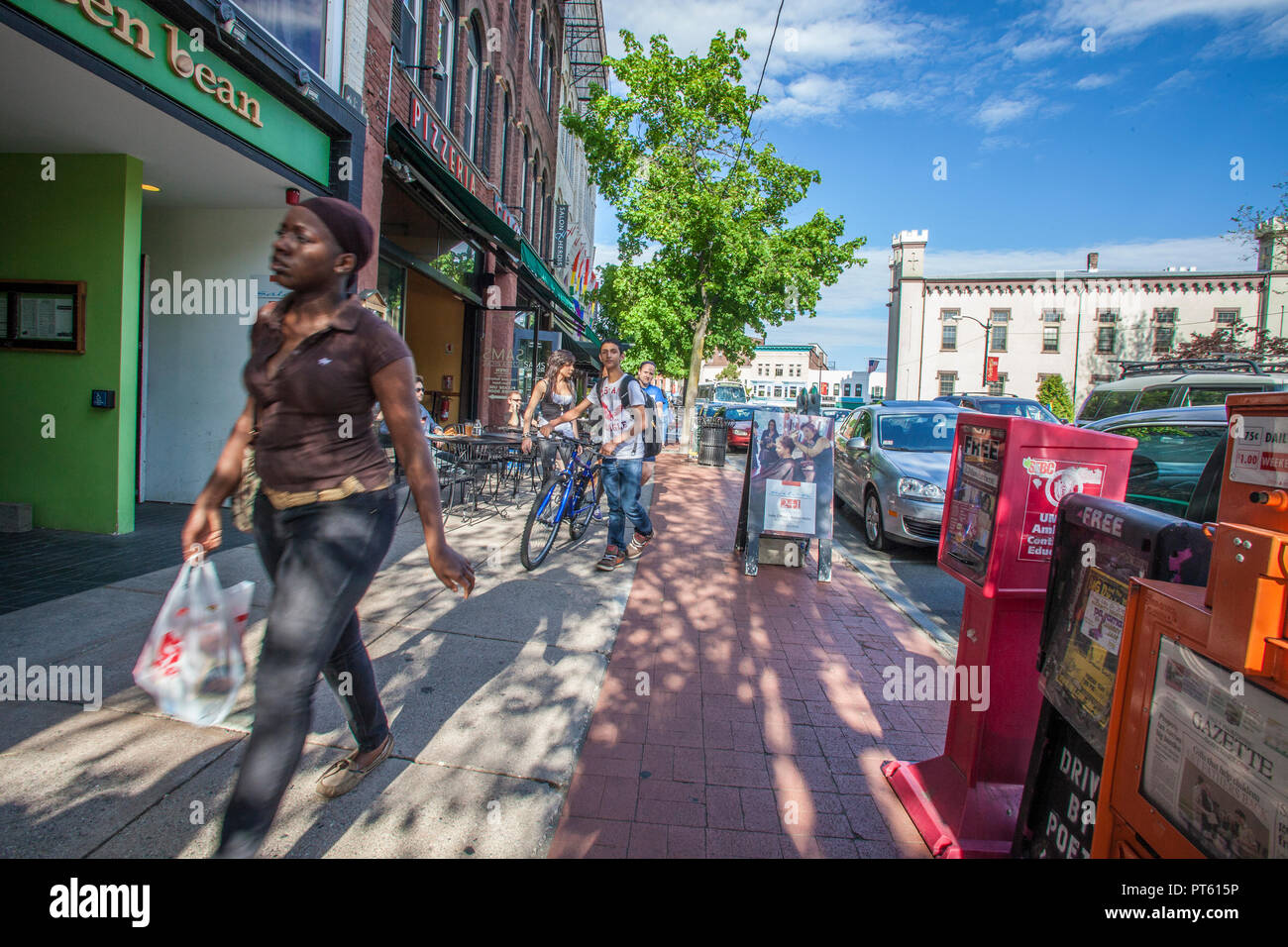 La gente che camminava lungo il marciapiede sulla trafficata strada principale a Northampton, MA Foto Stock