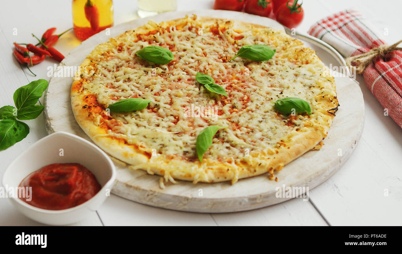 Una deliziosa pizza italiana servita su un tavolo di legno, girato da lato Foto Stock