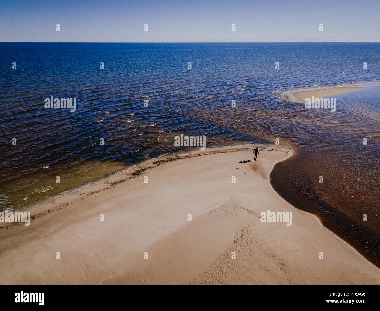 Vista aerea della spiaggia di Engure in Lettonia. Fiume incontra il Mar Baltico. Lonely Man sulla riva. Bella giornata di sole. Foto Stock