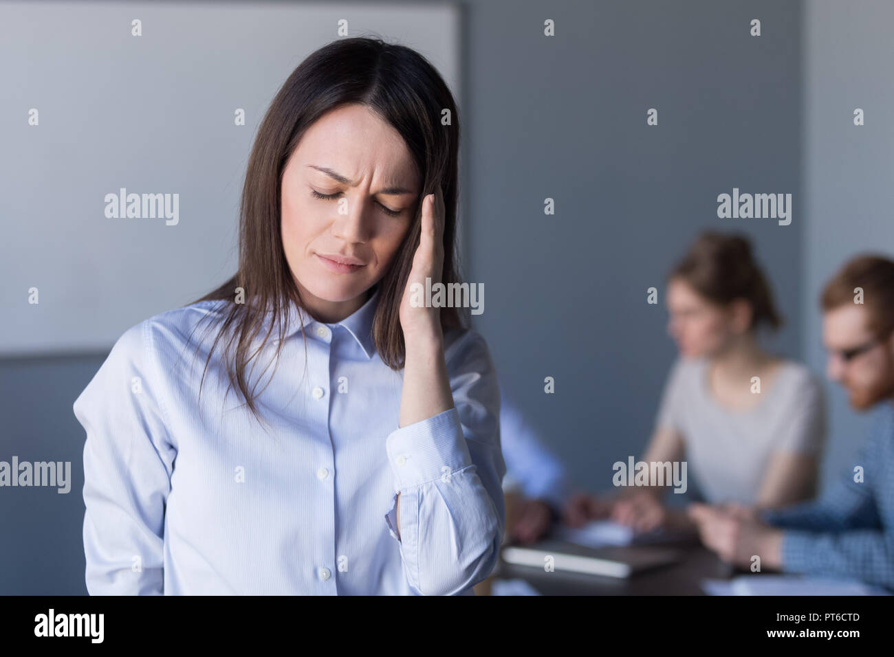 Sottolineato frustrato imprenditrice tempio toccante sensazione forte Foto Stock