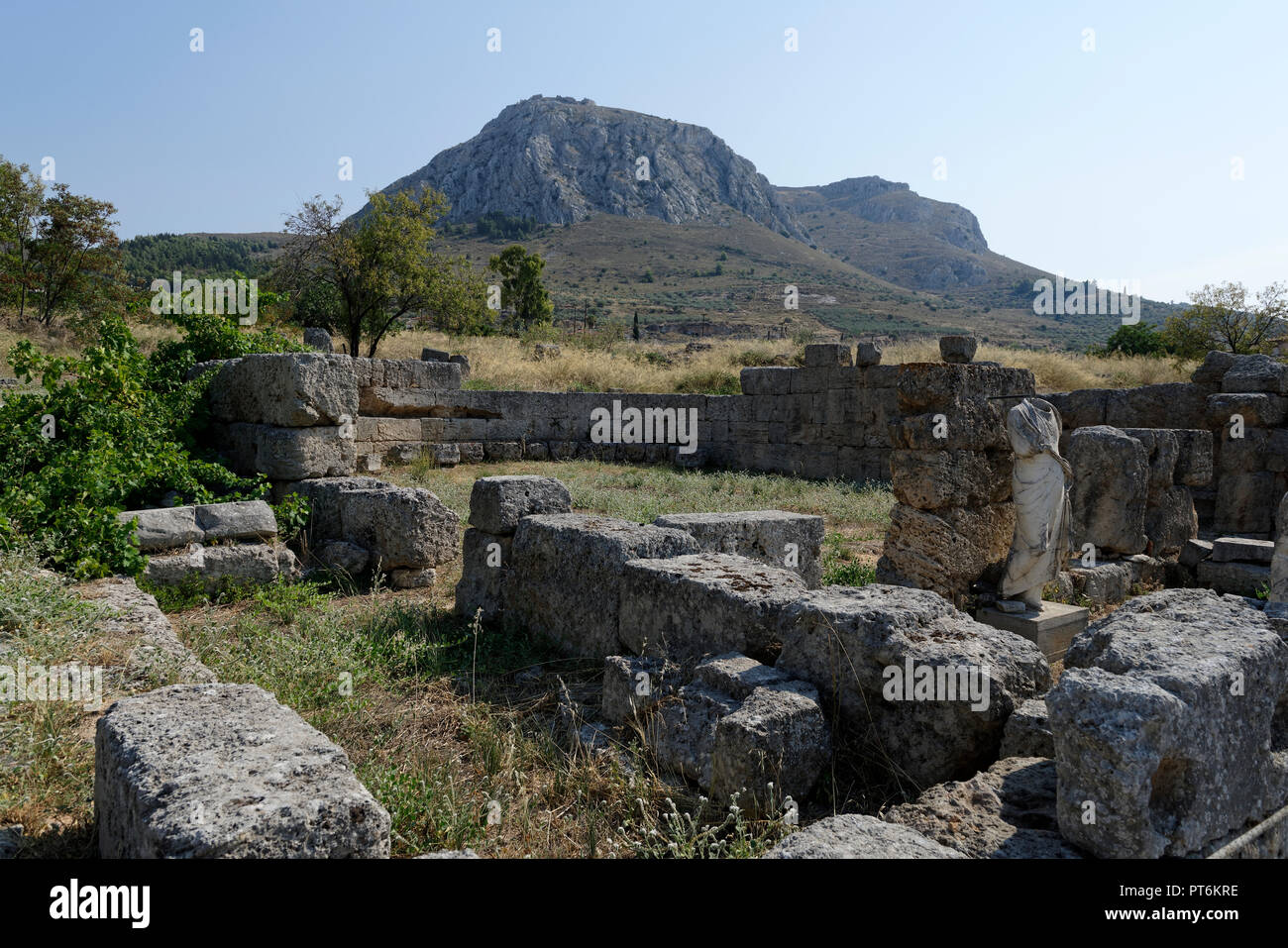 Una testa di antica statua in marmo di fronte il bouleuterion o in camera di consiglio. Antica Corinto. Peloponneso. La Grecia. L'edificio è parte dell'im Foto Stock Una testa di antica statua in marmo di fronte il bouleuterion o in camera di consiglio. Antica Corinto. Peloponneso. La Grecia. L'edificio è parte dell'im Foto Stock
