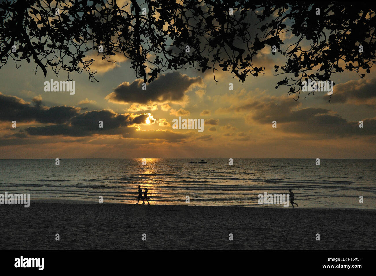 Silhouette di alcuni turisti jogging sulla spiaggia di Chaweng in Thailandia all'alba. Foto Stock