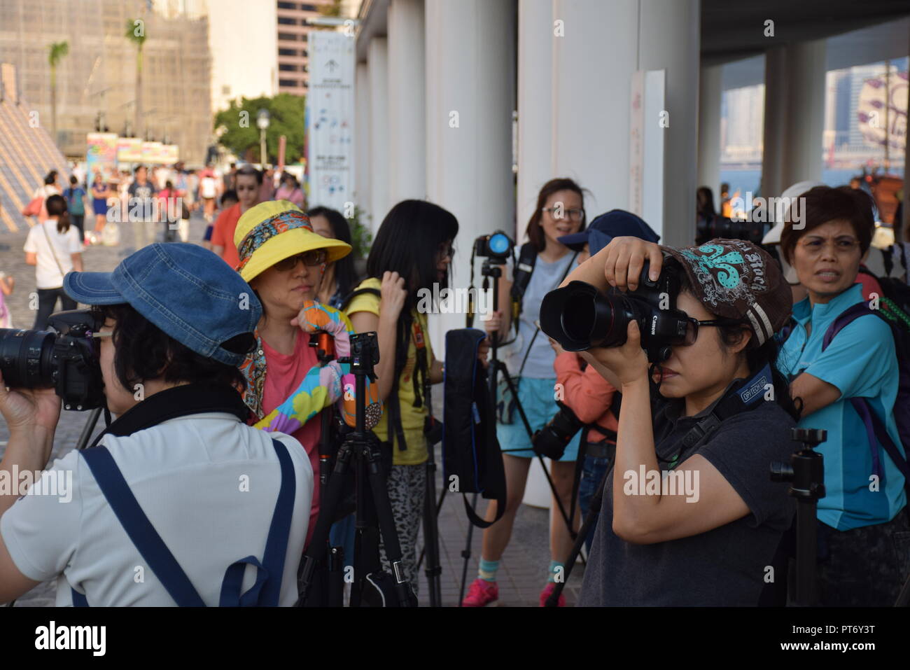 Il gruppo di donne cinesi di scattare le foto con le loro macchine fotografiche in Tsim Sha Tsui promenade di Hong Kong, Cina Foto Stock