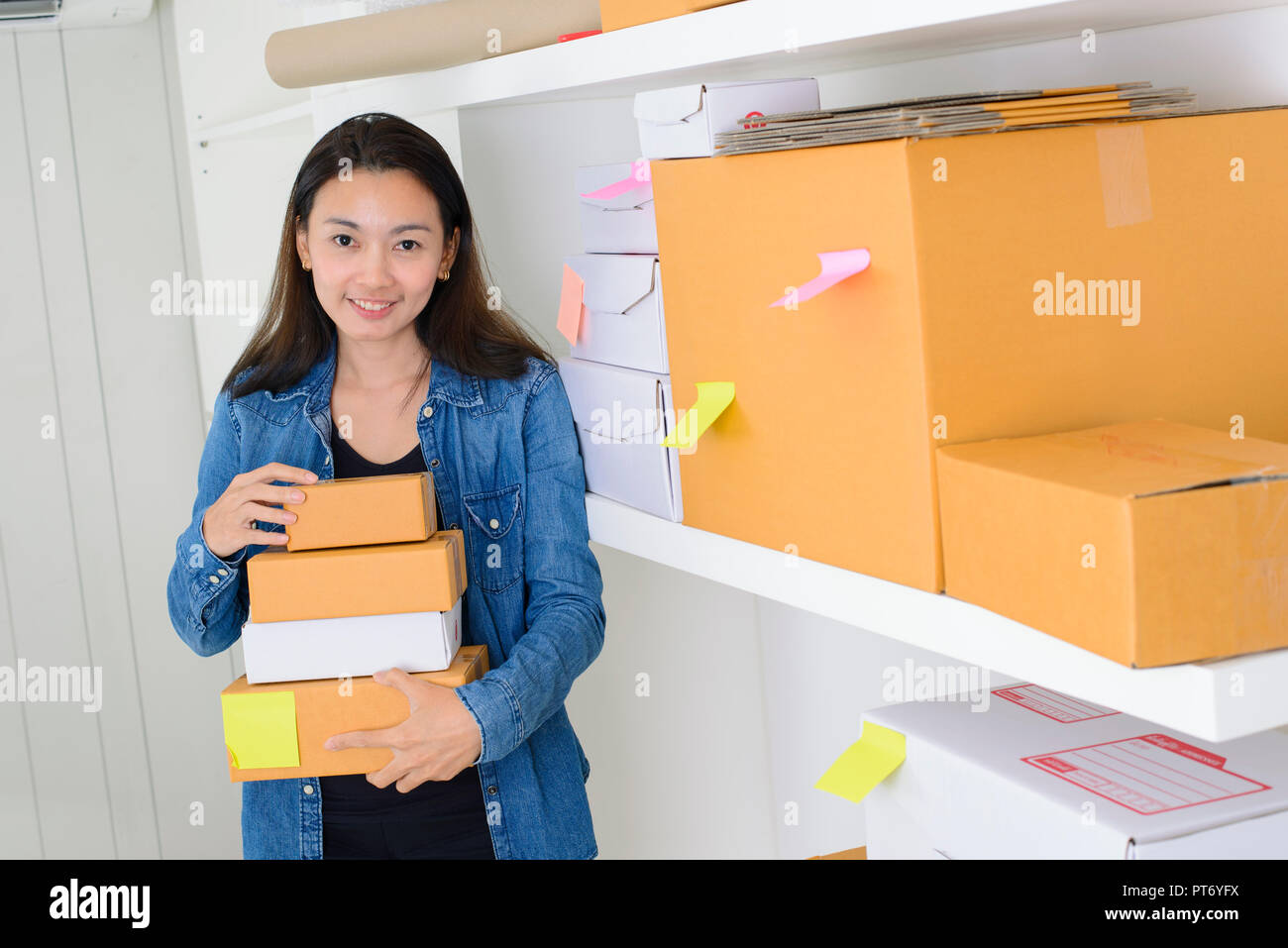 Donna asiatica il lavoro a casa ufficio controllo dell'ordine pronto per mailing o spese di spedizione Foto Stock