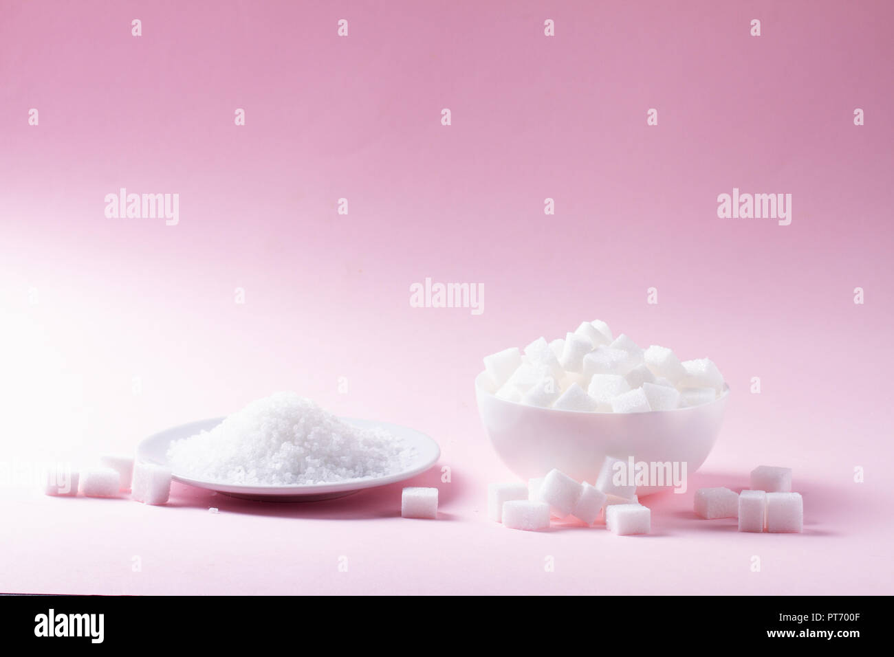 Lo zucchero in cubetti di cristallinità abd su sfondo rosa Foto Stock