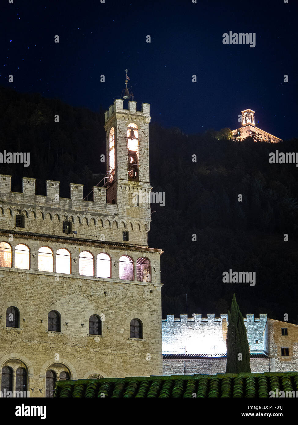 La fotografia notturna del Palazzo dei Consoli di Gubbio e in alto a destra, il monastero di Sant'Ubaldo Foto Stock