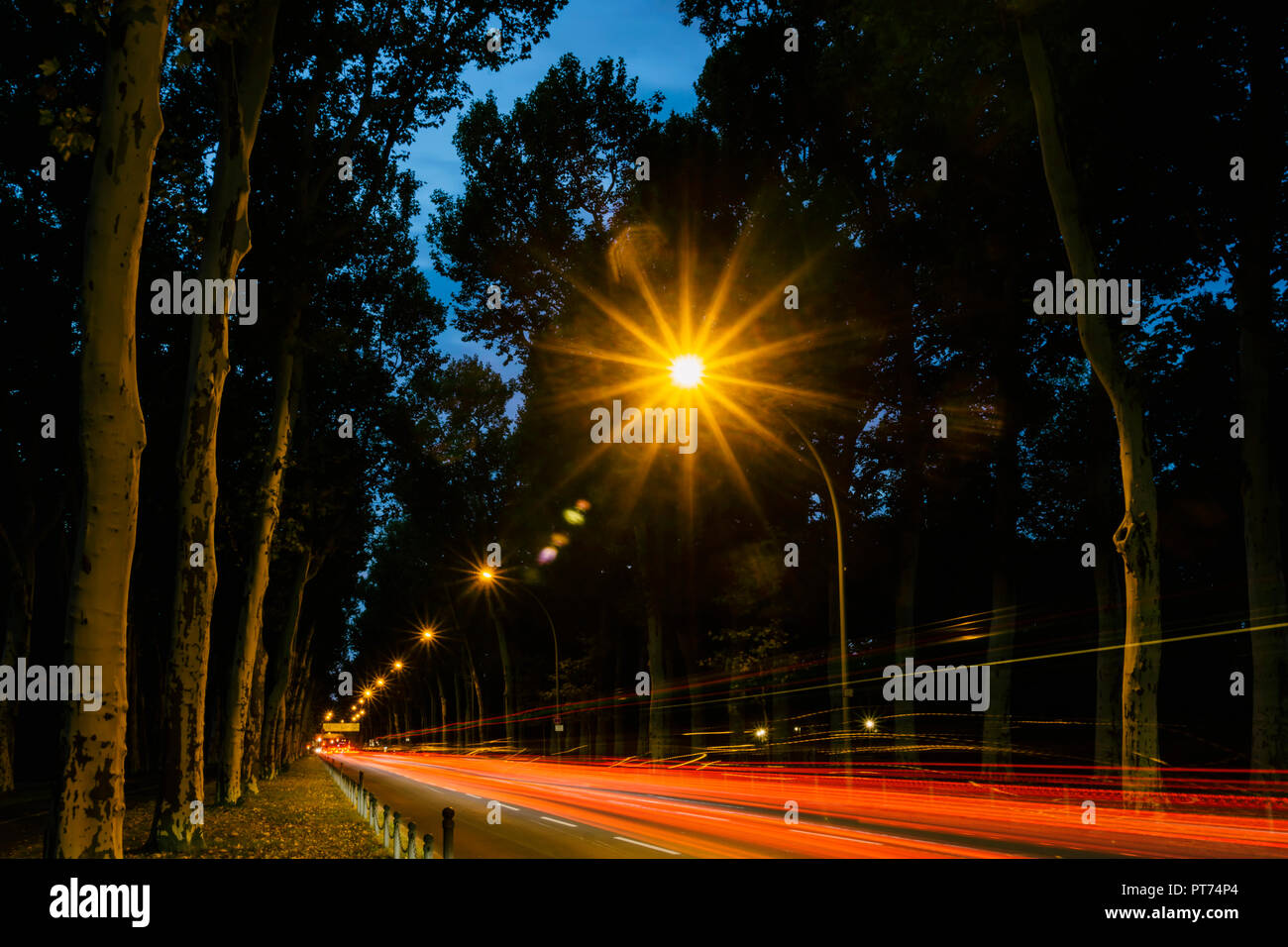 Berlino, Germania, Ottobre 06, 2018: Vicolo al crepuscolo con lampioni e sentieri di luce del traffico Foto Stock