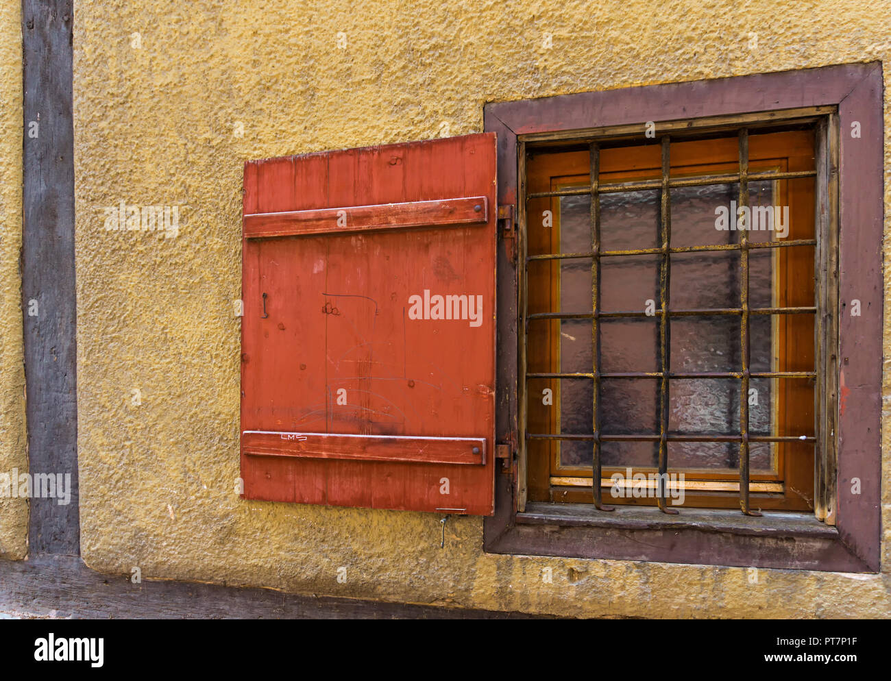 Un vecchio,finestra in legno con barre di ferro Foto Stock