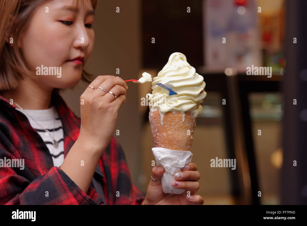 Praga, Repubblica Ceca - 14 Settembre 2018: donna cinese di mangiare Trdelnik con gelato all'esterno. Questo ceco tradizionale torta allo spiedo con vari riempire Foto Stock