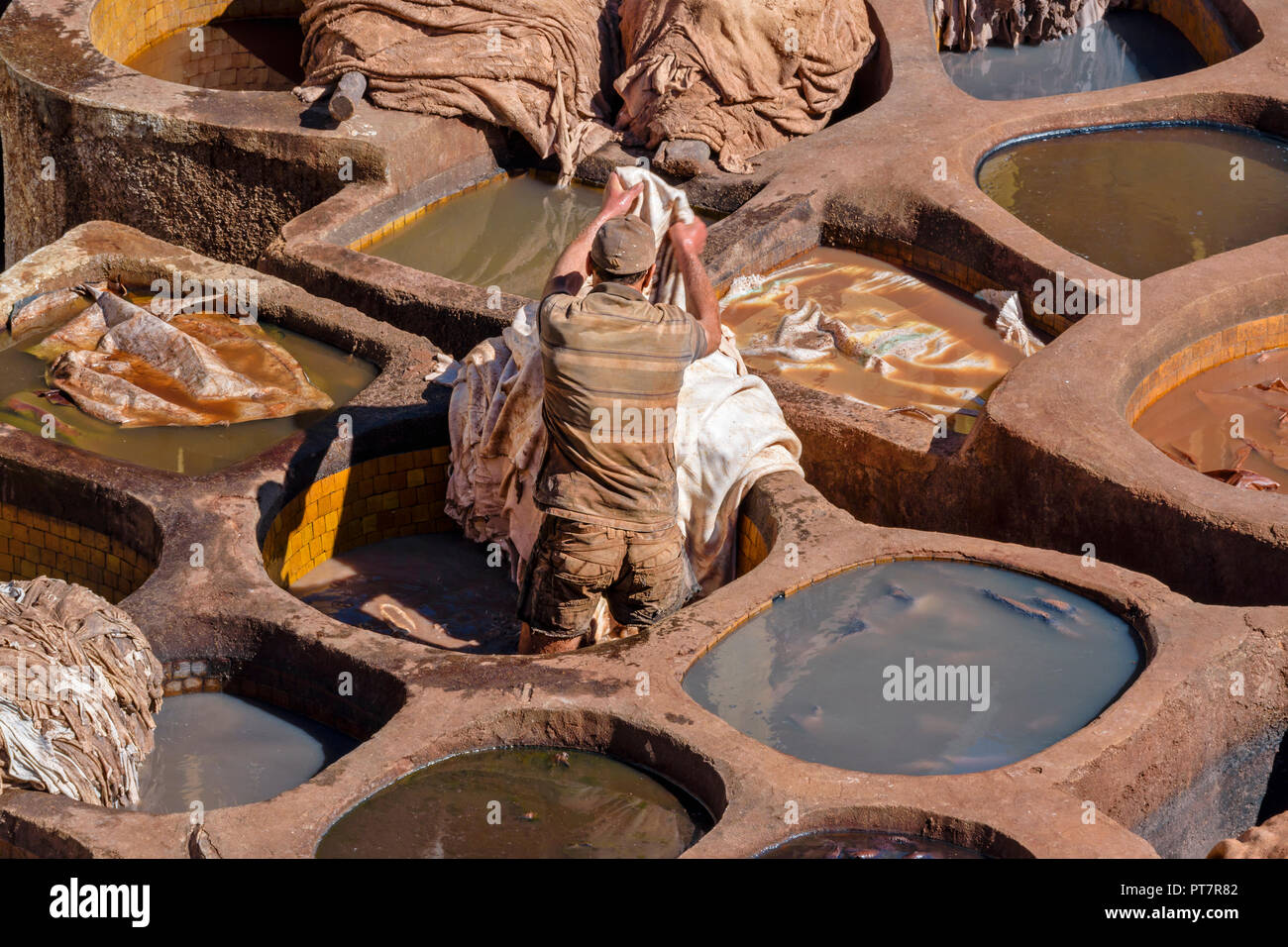 Il Marocco Marrakech conceria cuoio singolo TANNER lavorando in tini in piastrelle di pigmenti colorati e pelli Foto Stock