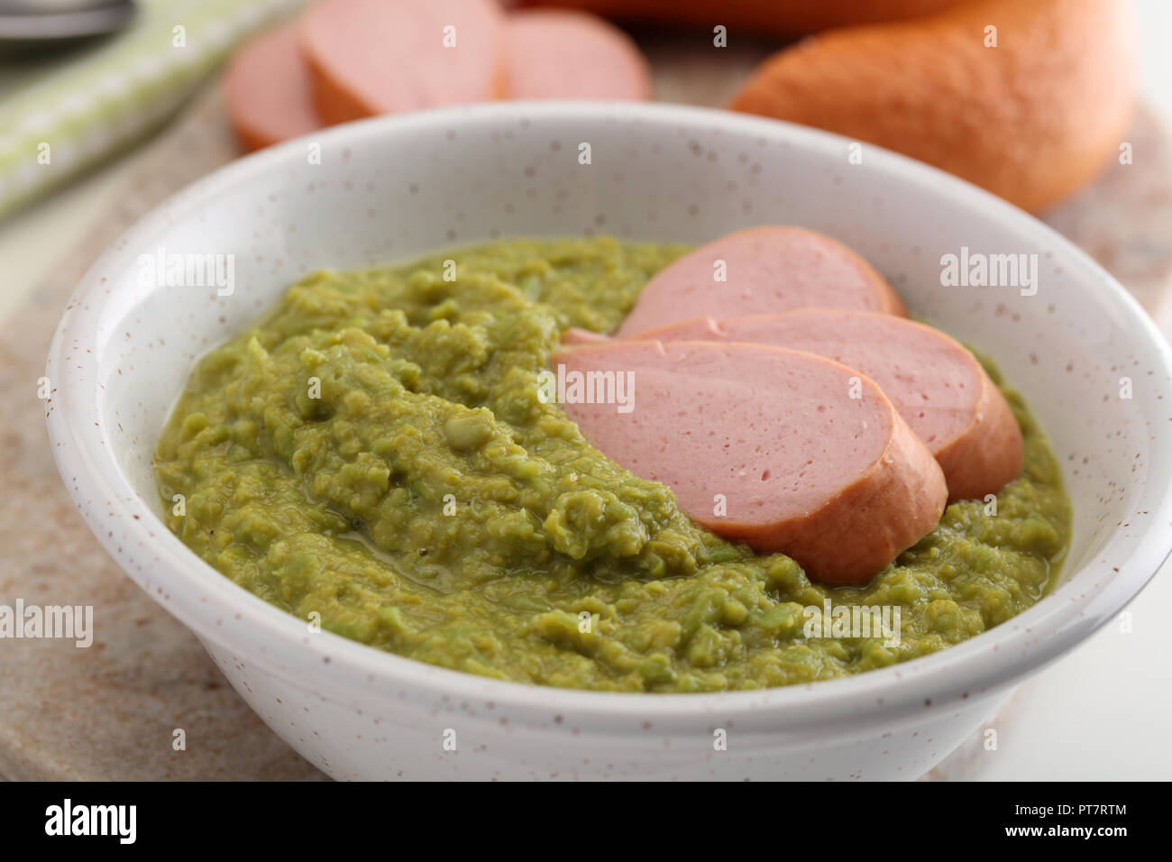 Tradizionale olandese Rookworst salsiccia con purè di piselli su un tavolo rustico Foto Stock