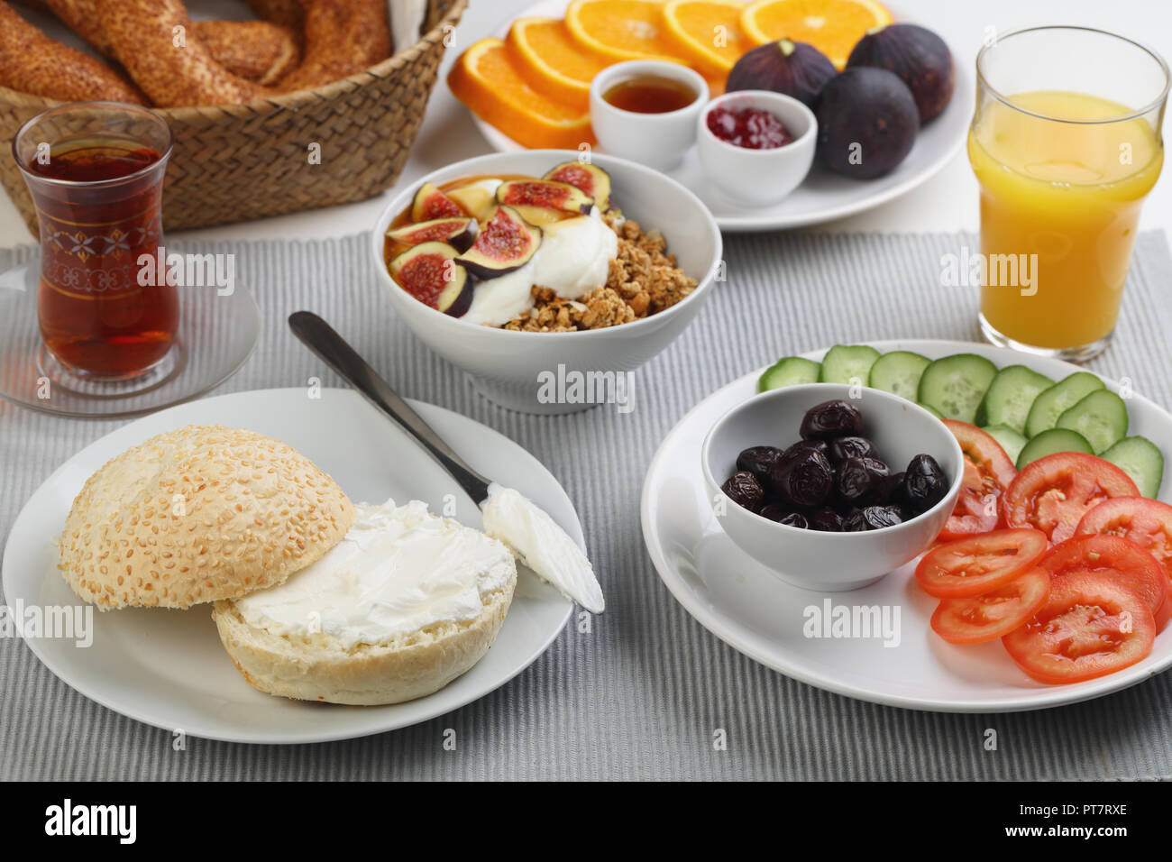 Bagno turco Colazione con crema di formaggio, verdure, granola, simits, frutta, succhi di frutta e tè Foto Stock