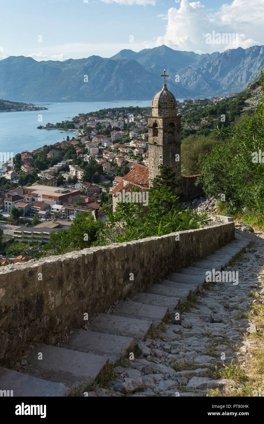 Vista in elevazione della storica medioevale della città murata di Kotor in Montenegro guardando giù sentiero di montagna per la Chiesa di Nostra Signora del Rimedio torre campanaria. Foto Stock