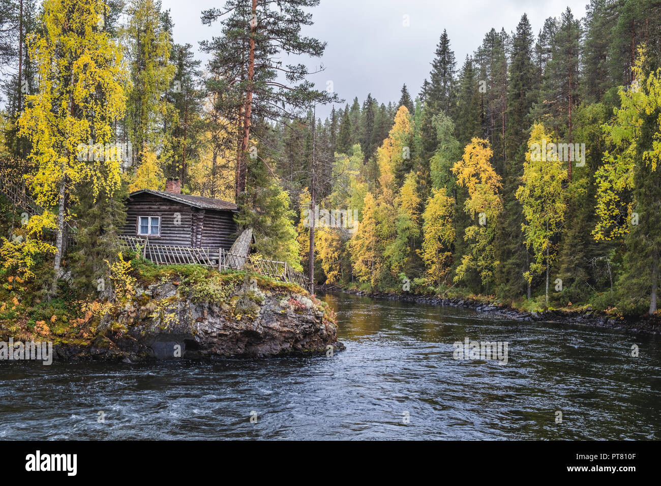 Bellissimi colori autunnali con cabina e lungo il fiume in autunno il giorno in Myllykoski, Kuusamo, Finlandia Foto Stock