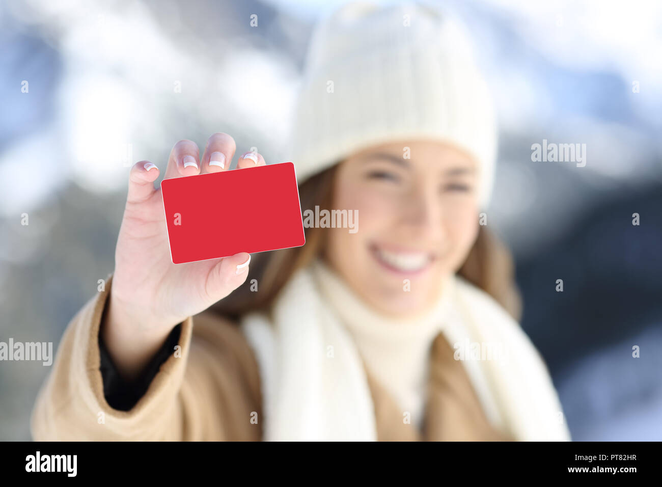 Felice donna vestita di cuore che mostra un fustellato carta di credito in inverno vacanze in montagna Foto Stock