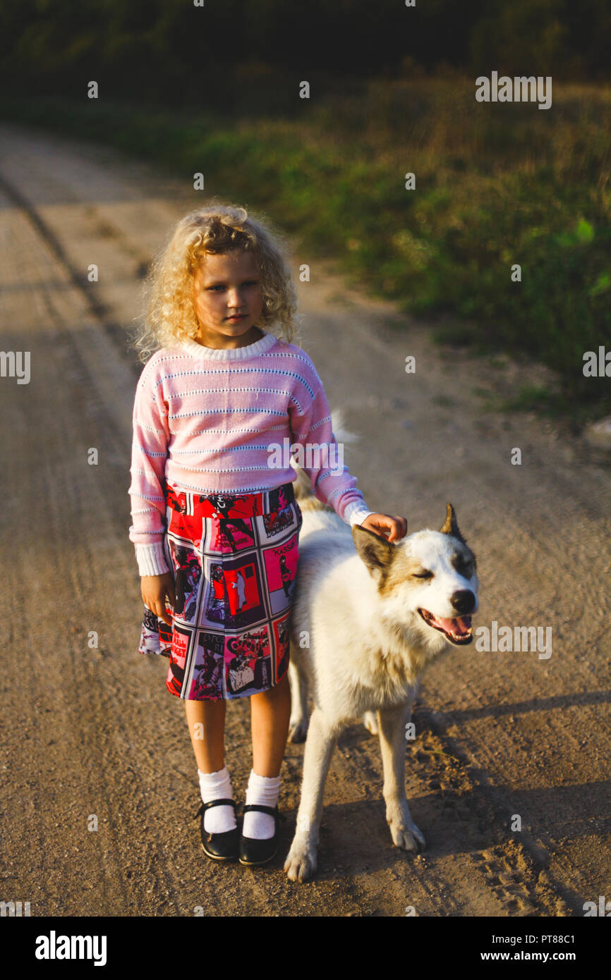 Curly blonde bambina e big dog Foto Stock