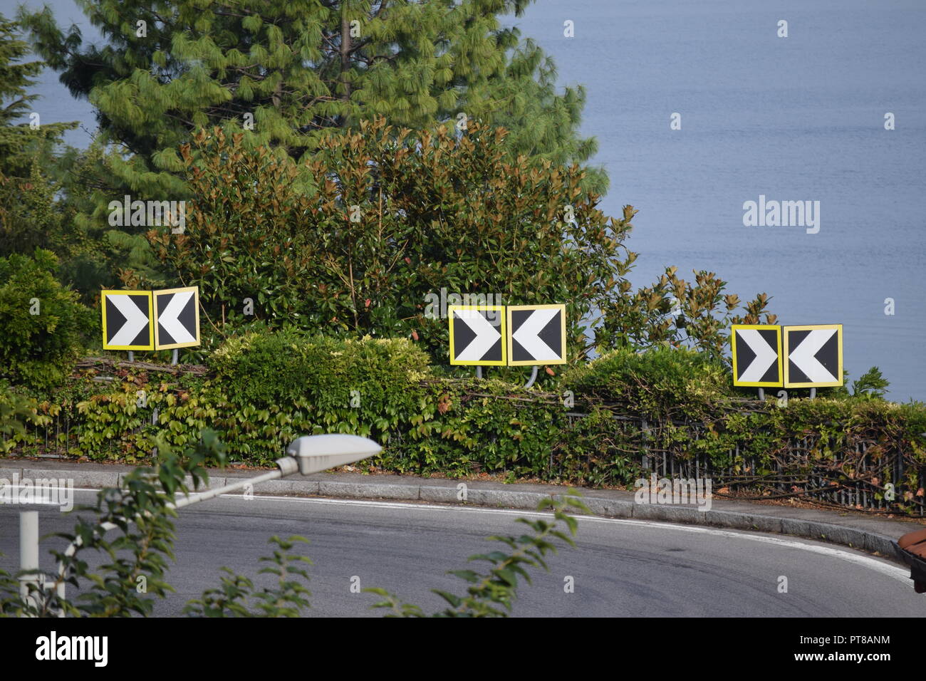 Curva pericolosa su una stretta strada attraverso la montagna a Argegno, Lago di Como, Italia Foto Stock