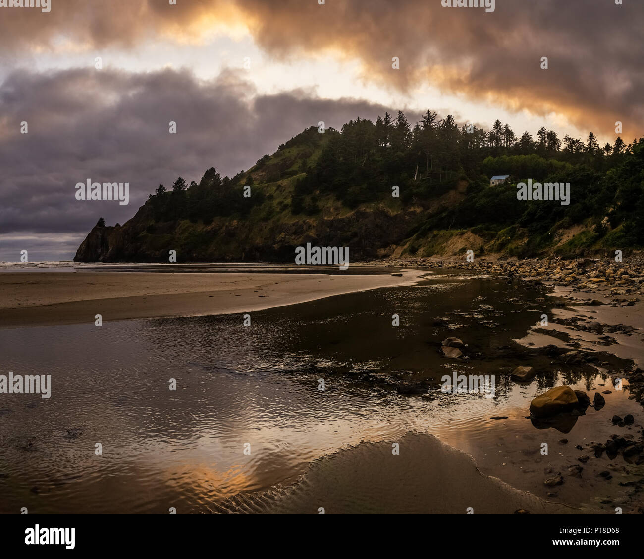 Bellissimo e drammatico tramonto sulla spiaggia di Agata e poco Schooner Creek e Yaquina Capo, Newport, Oregon Coast, Stati Uniti d'America. Foto Stock