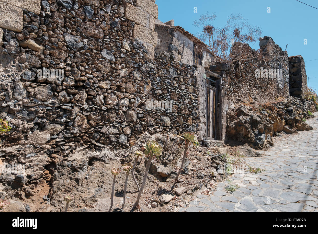 Vecchio edificio esterno con i muri in pietra naturale, edificio rovine Foto Stock