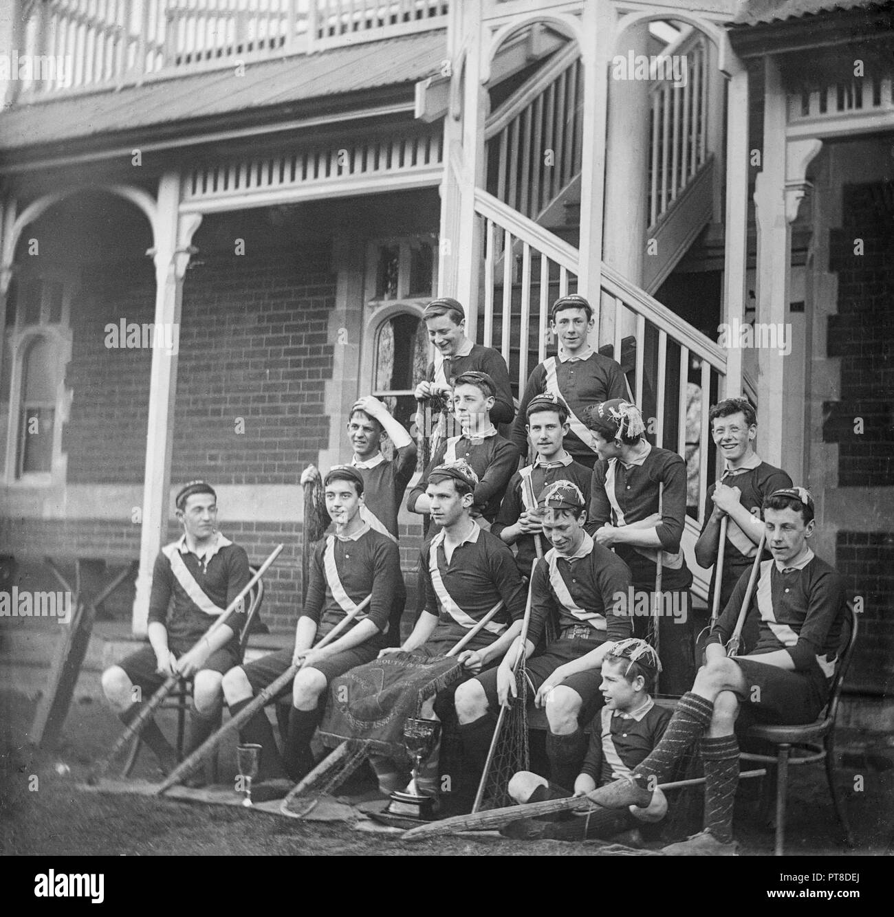 A fine ottocento o dei primi del XX secolo fotografia in bianco e nero che mostra un ragazzi squadra di lacrosse, visualizzando due trofei. Foto Stock