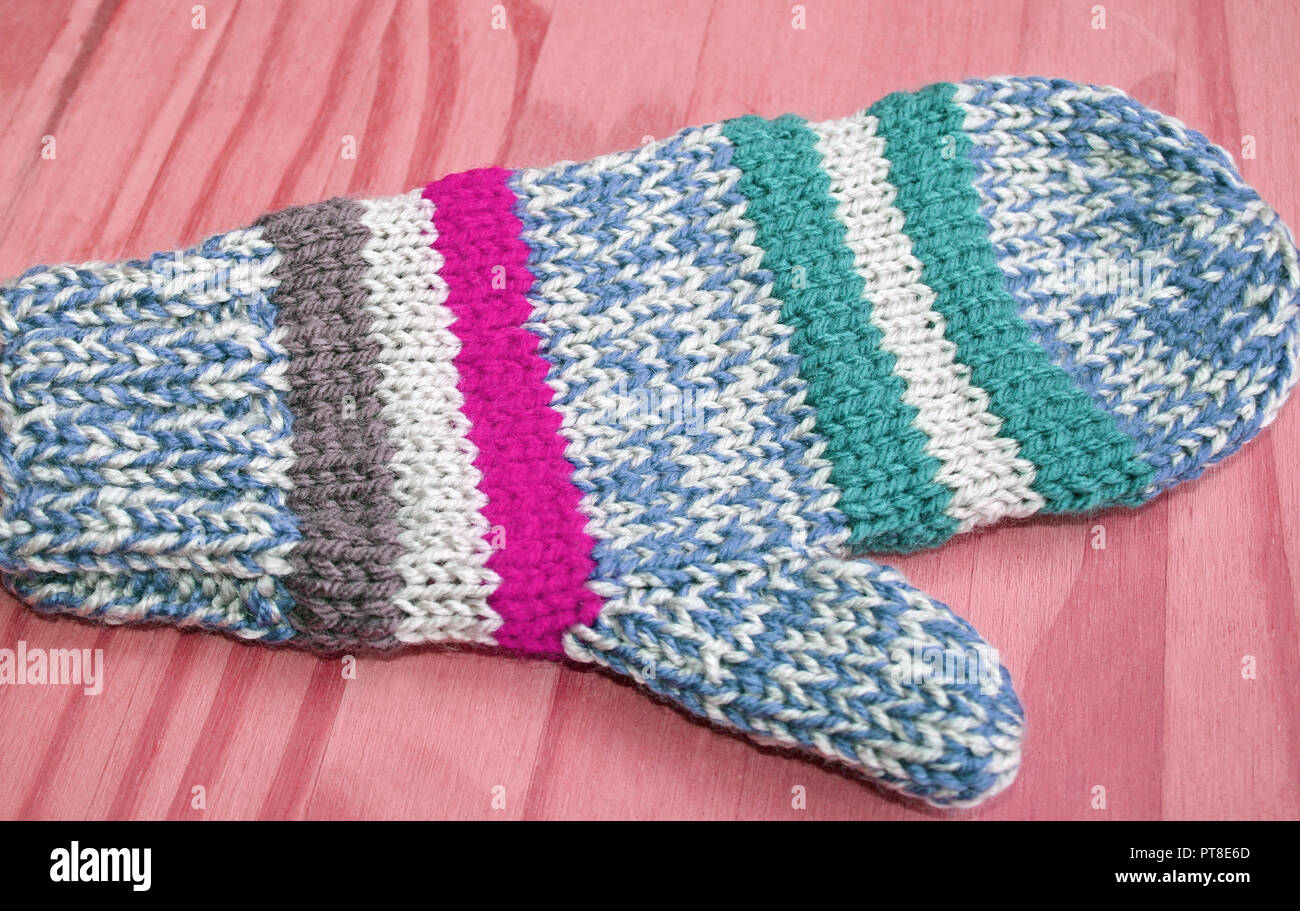 Luminose e colorate a mano a maglia mitten in blu, bianco, rosa e strisce verdi Foto Stock