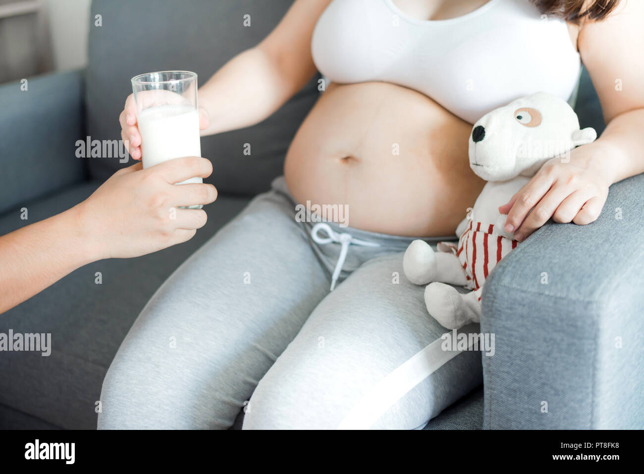 Asian donna incinta con grande pancia. Rilassarsi a casa con il marito. Foto Stock