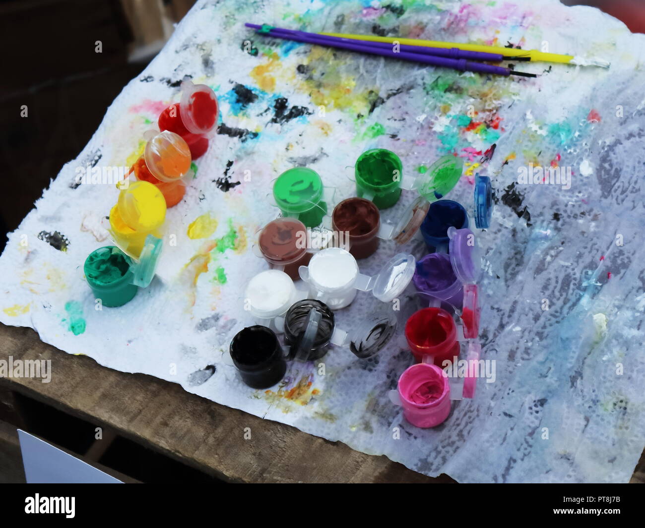 Utensili di una faccia del festival pittore con pennelli e colori su un tavolo Foto Stock