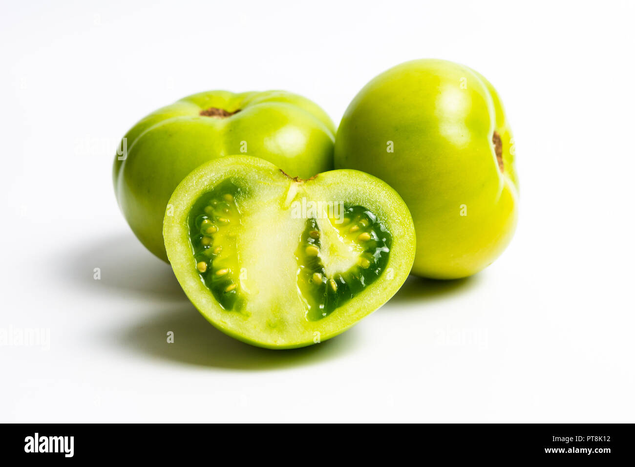 Fette di pomodoro verde su sfondo bianco Foto Stock